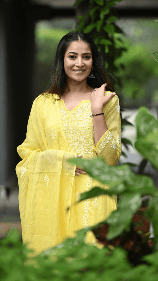 Woman wearing a yellow chikankari outfit with a dupatta in an outdoor setting by Pakke Dhaage