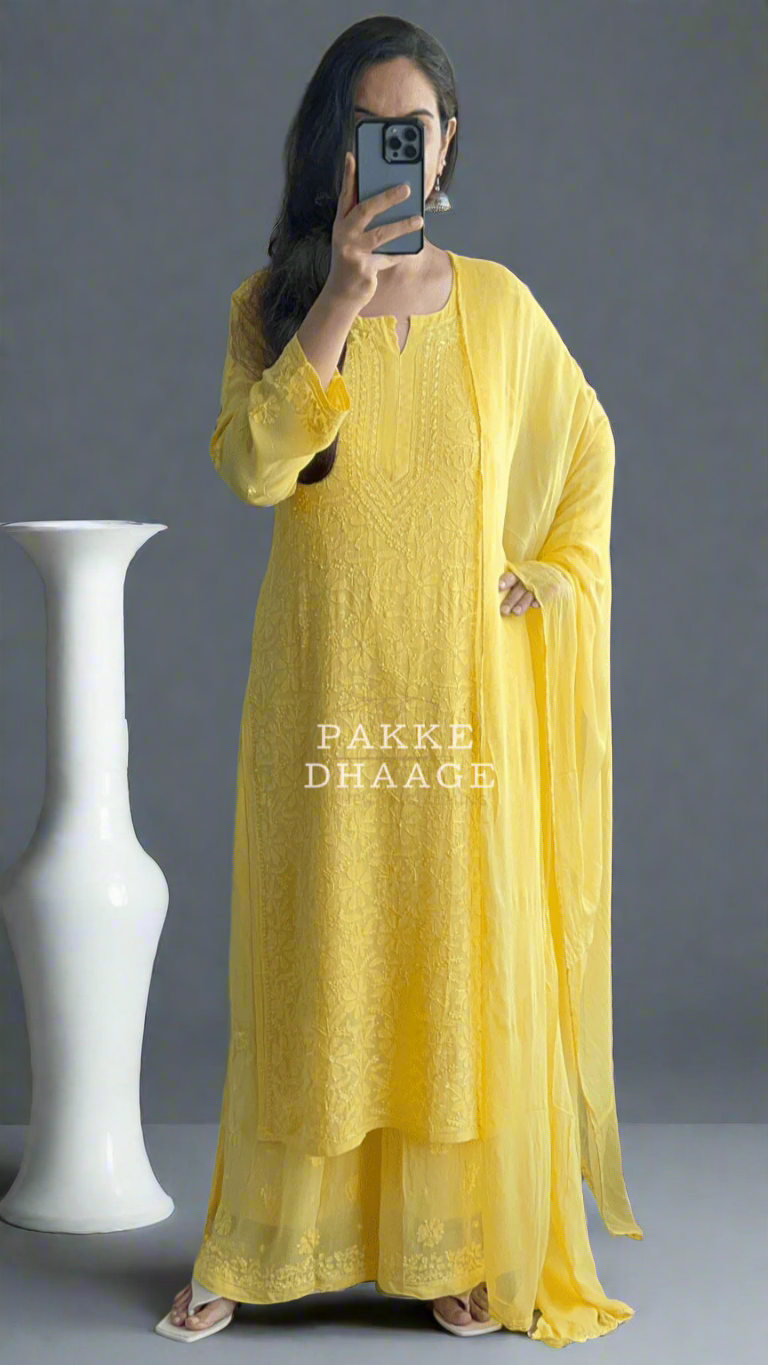 Person wearing a yellow chikankari outfit with 'Pakke Dhaage' branding in an outdoor setting.