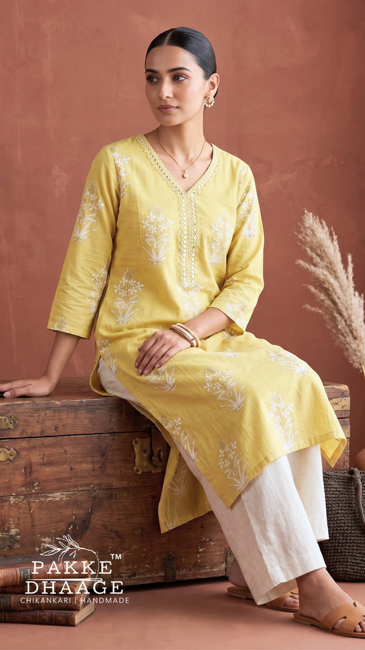 Model wearing Pakke Dhaage lemon yellow floral printed V-neck cotton kurta paired with white trousers.