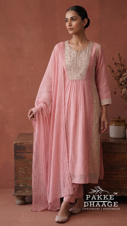 A woman models a light pink Kurta Set  with a matching sheer dupatta, featuring a cream embroidered neckline by Pakke Dhaage