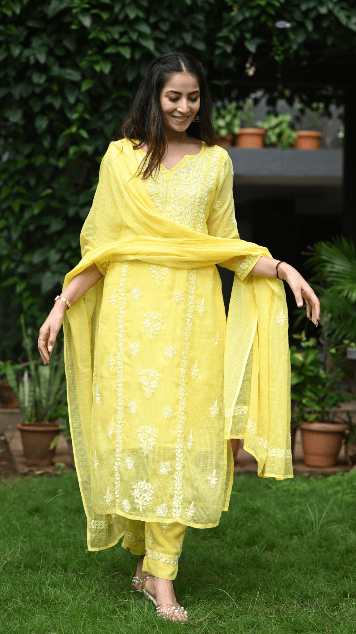 Woman wearing a yellow chikankari outfit with a dupatta in an outdoor setting
