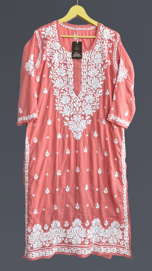 Coral dress with white floral chikankari embroidery on a hanger against a dark background