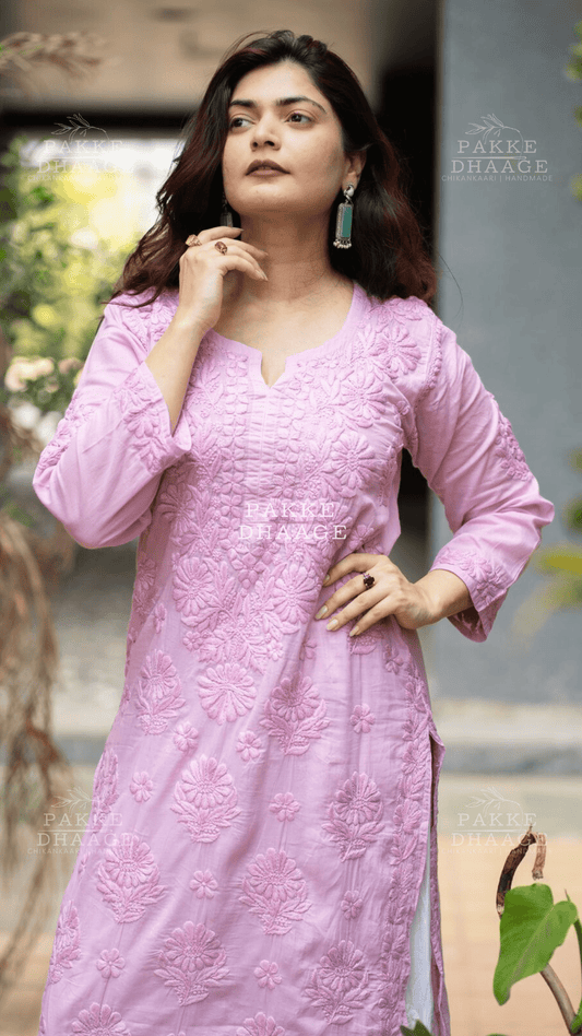 Woman wearing a pink chikankari embroidered kurti with a blurred outdoor background