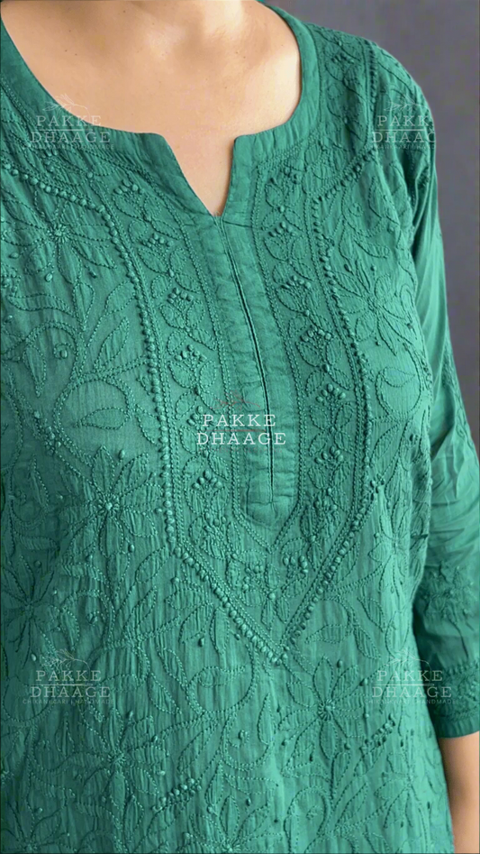 Green chikankari embroidered garment with 'Pakke Dhaage' branding.