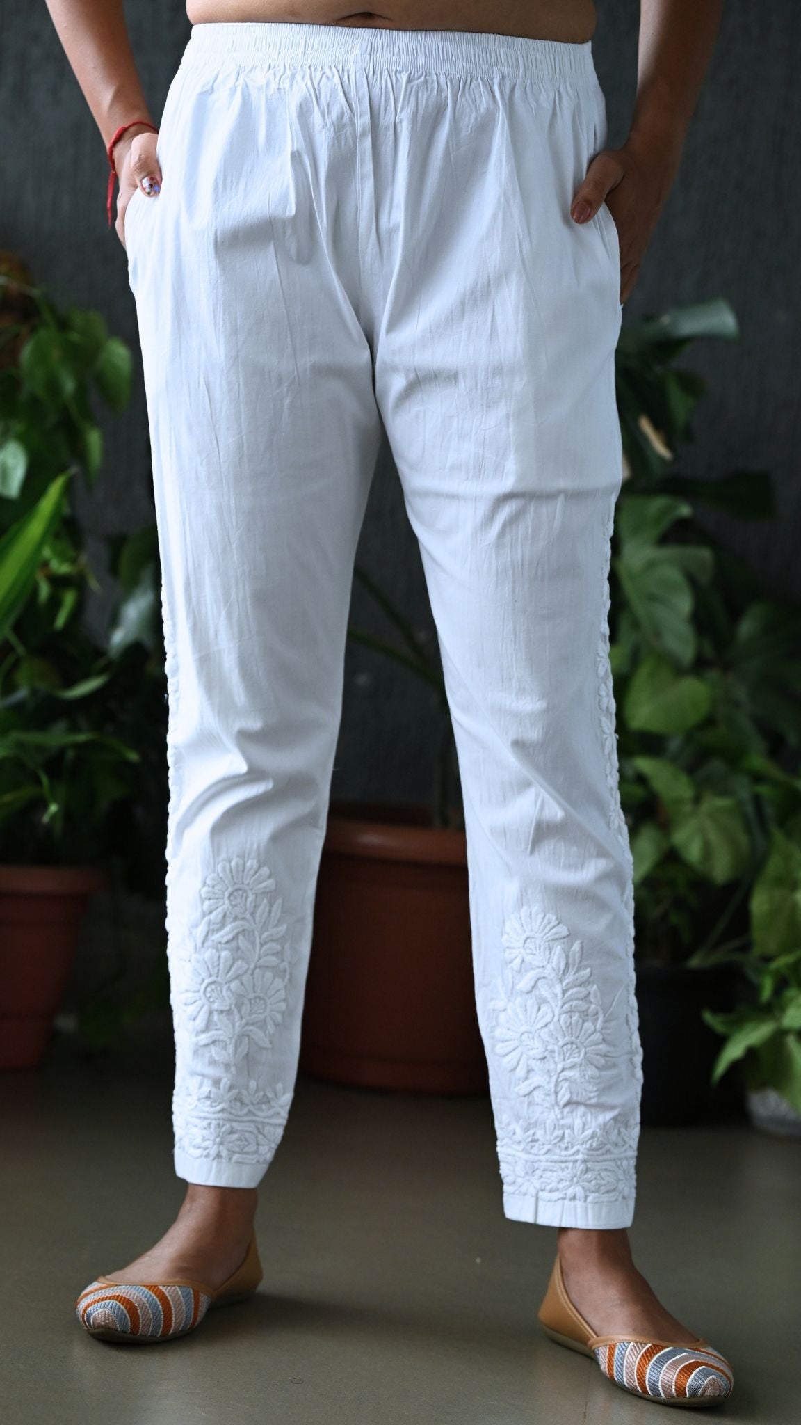 Front view of women's white hand-embroidered cotton Chikankari cigarette pants with side pockets by Pakke Dhaage.
