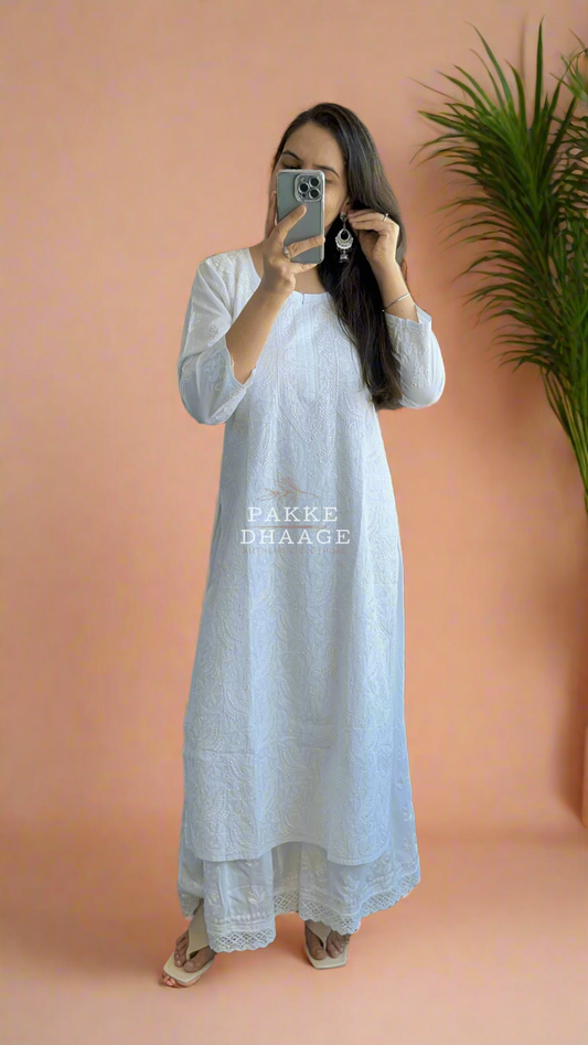 Woman wearing a white chikankari kurta with a hand embroidered chikankari palazzo