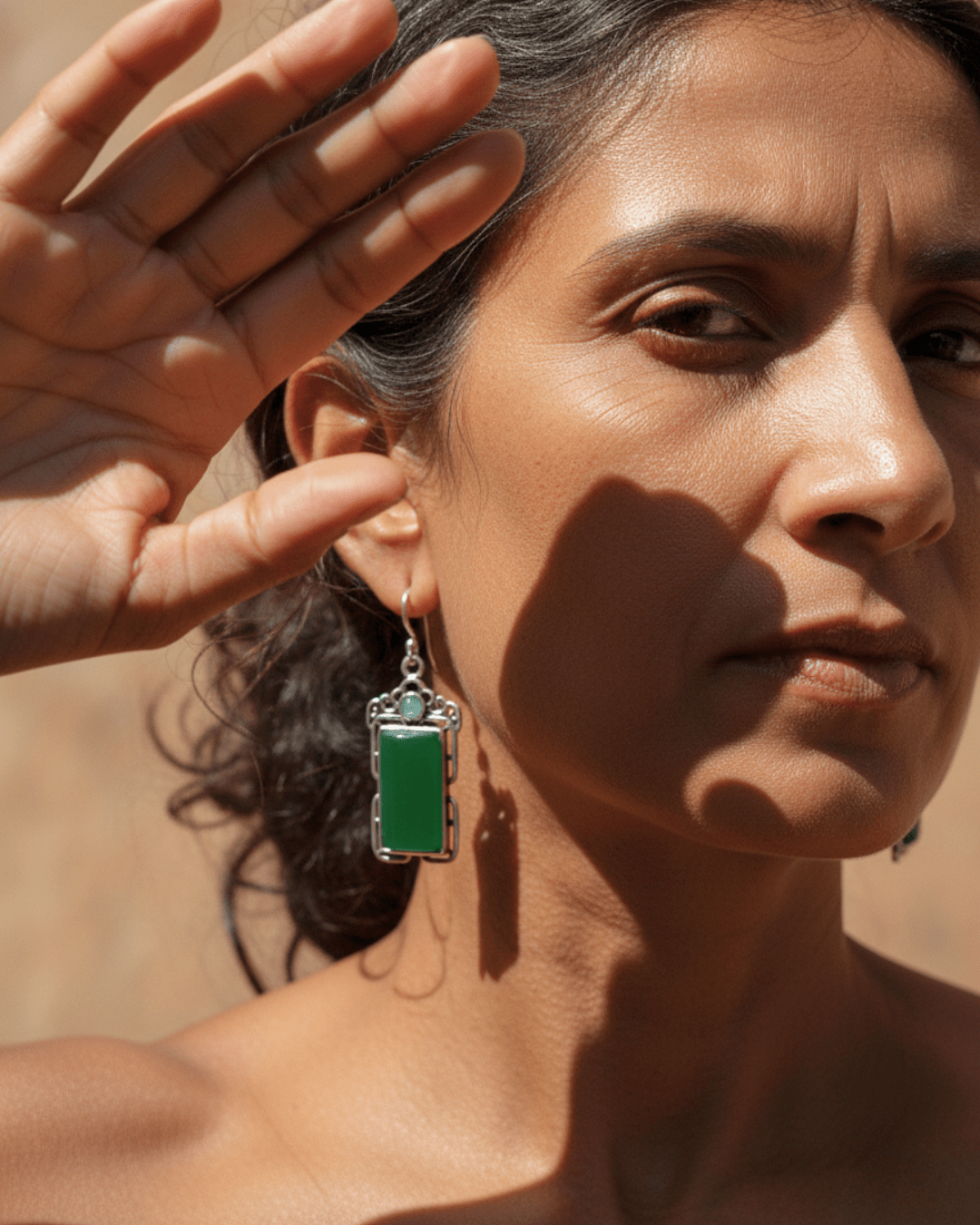 Woman wearing a green handmade oxidized earring with a blurred background