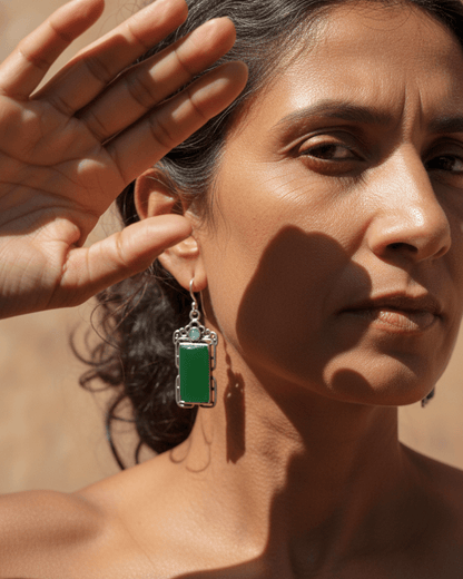 Woman wearing a green handmade oxidized earring with a blurred background