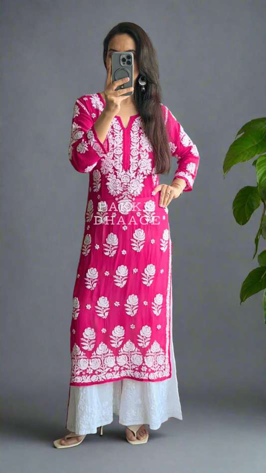 Person wearing a pink and white traditional chikankari handmade kurti in front of a mirror.