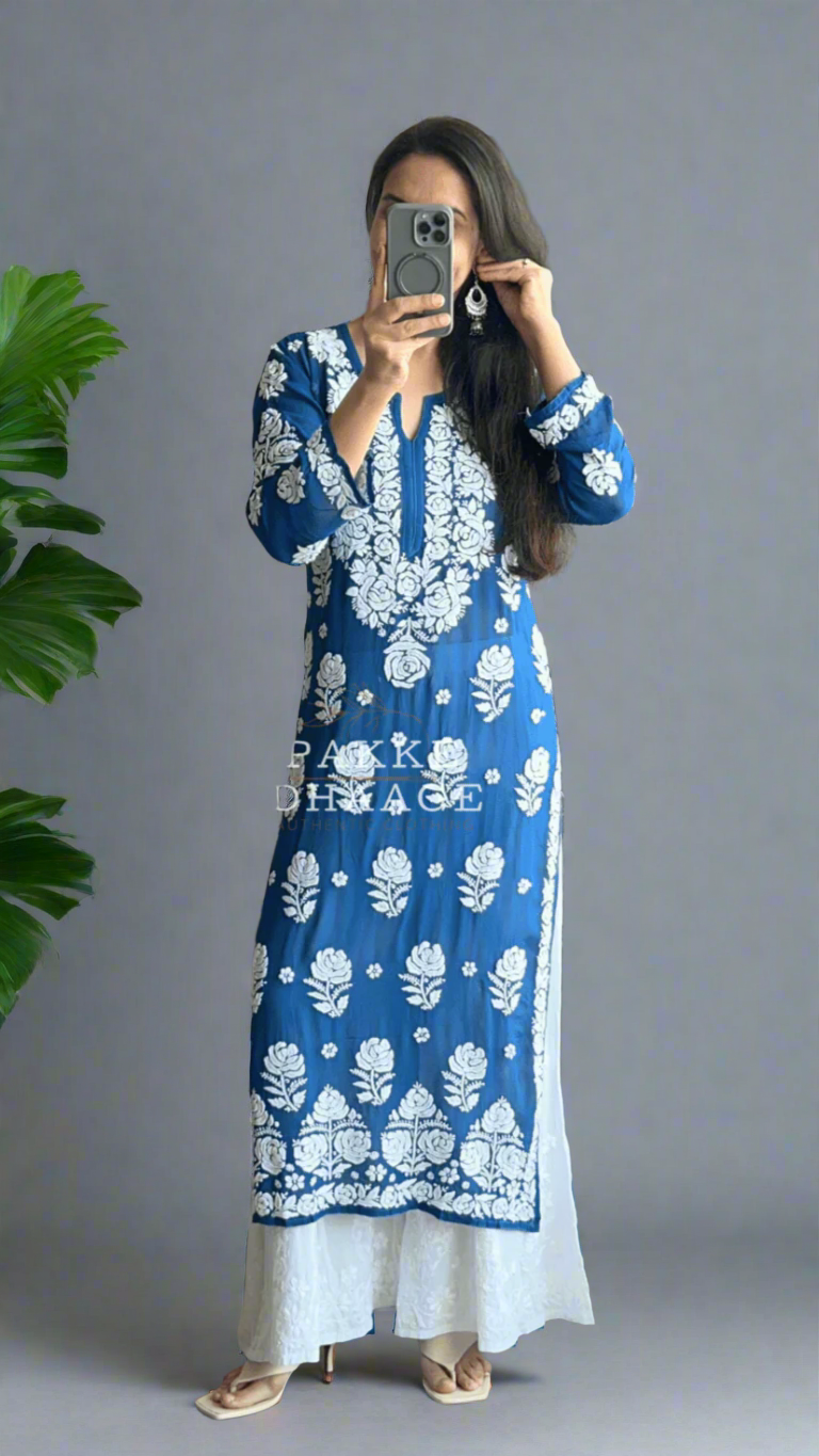 Person wearing a blue and white chikankari kurti with floral patterns in front of a mirror.