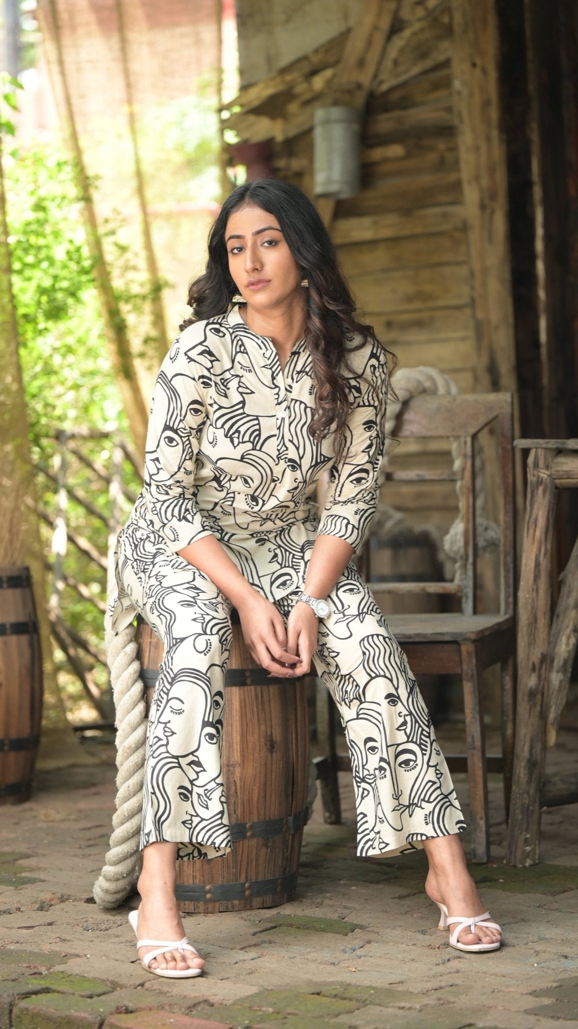 Woman wearing a printed pattern co-ord set, sitting in a rustic setting