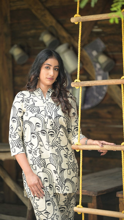 Woman in a patterned co-ord set standing on a wooden structure with a rustic background