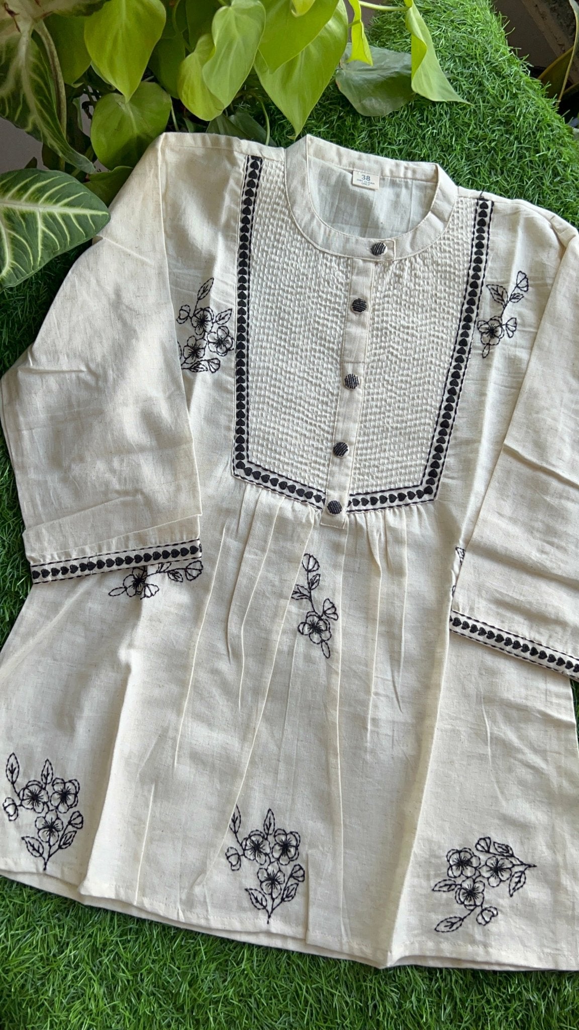 White embroidered top on a grass background, by Pakke Dhaage
