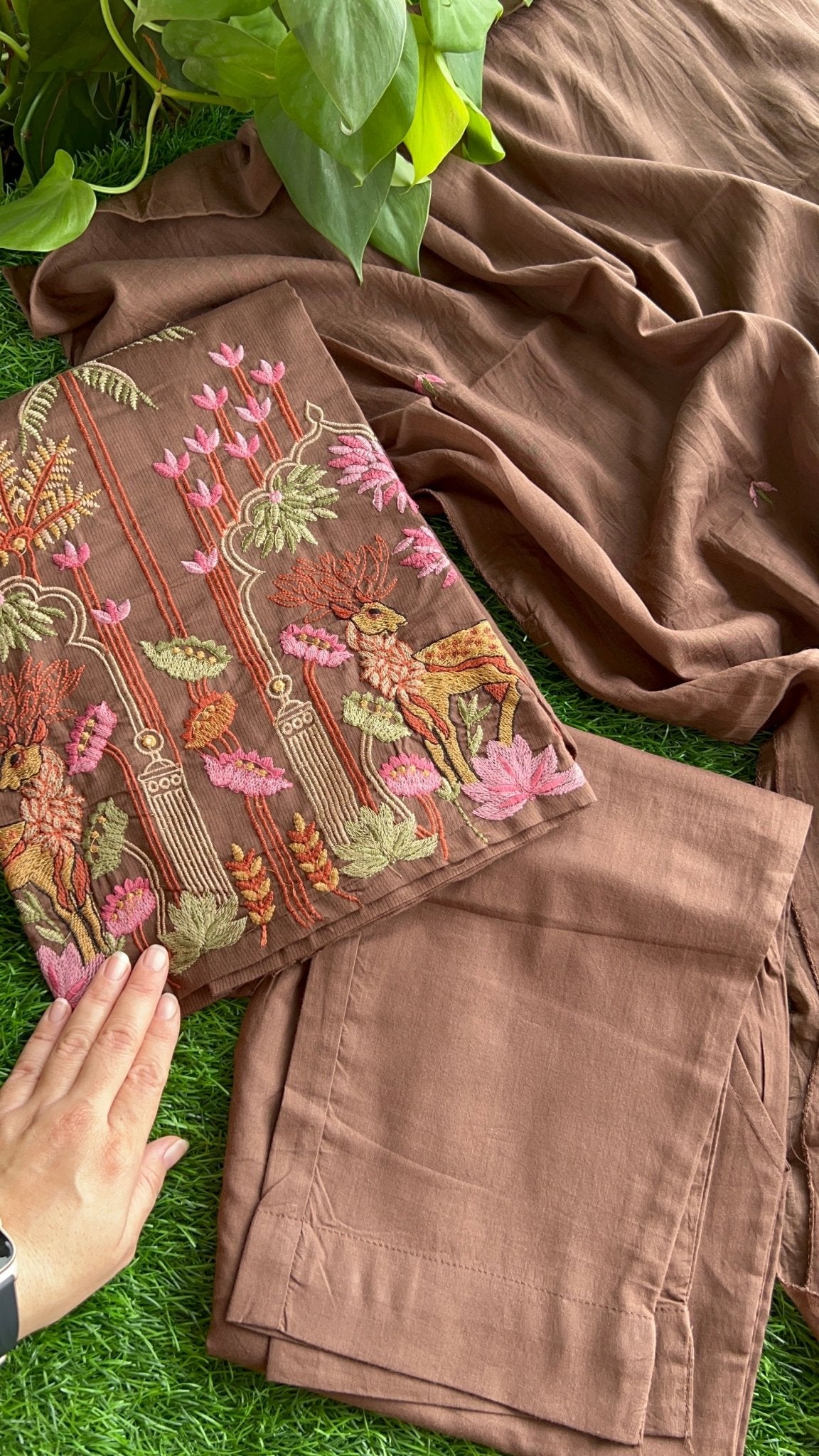 Brown embroidered suit set with floral patterns on a grassy surface
