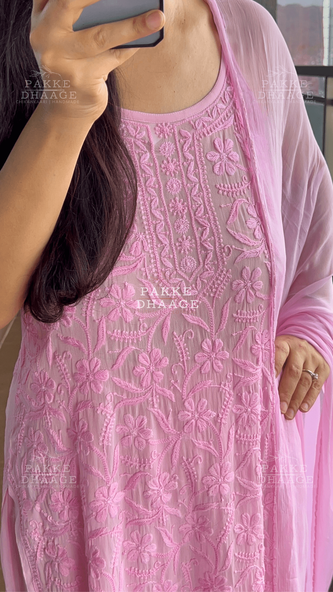 Person wearing a pink hand-embroidered chikankari dress in mulmul fabric.