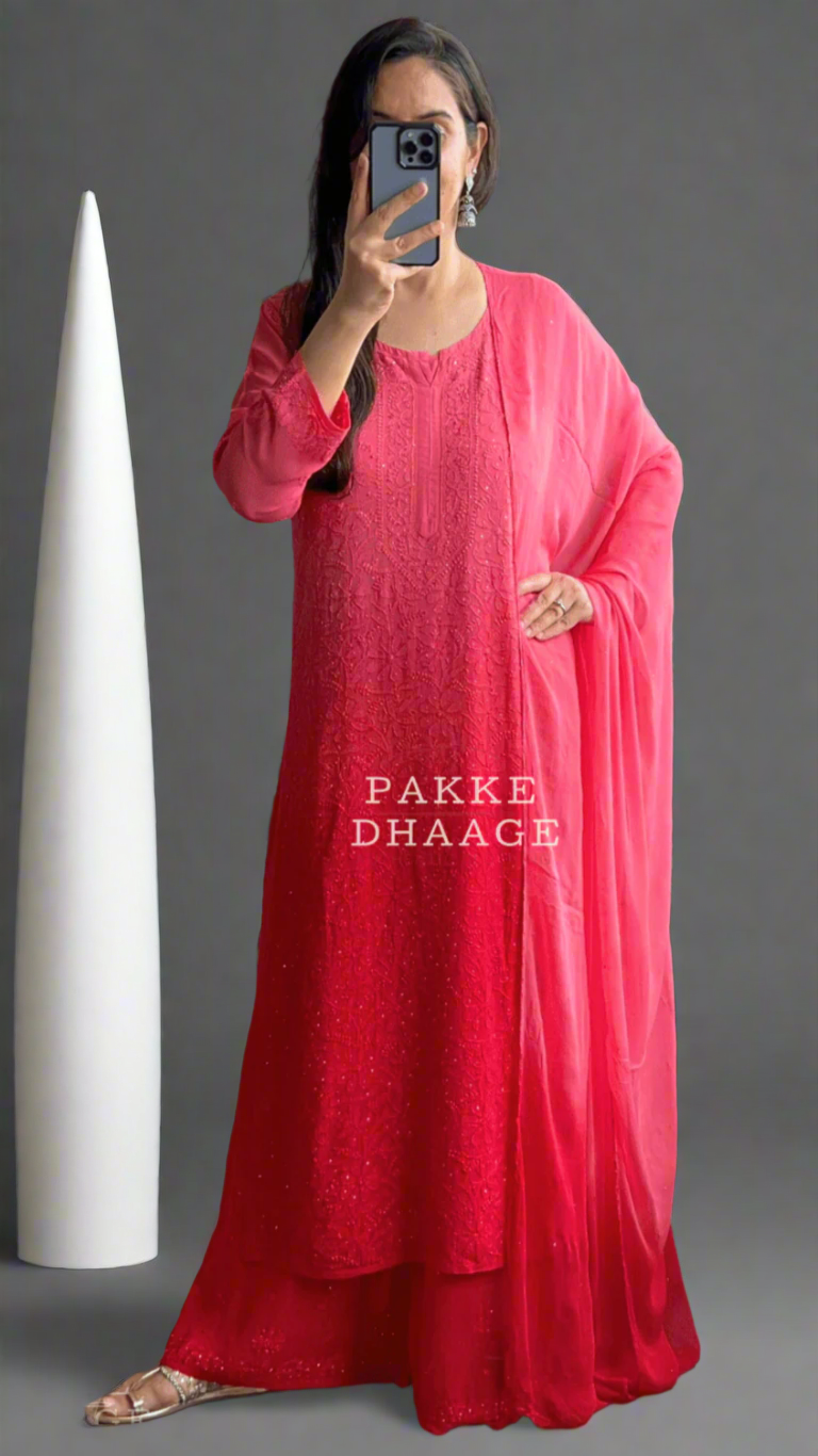 Person wearing a red chikankari suit standing in front of a mirror