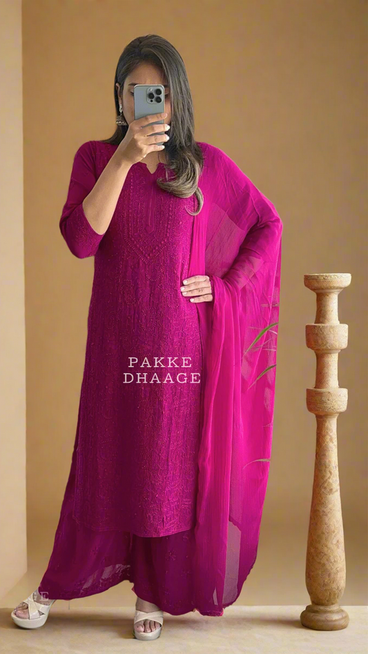 Person wearing a bright pink traditional chikankari outfit with a sheer dupatta, standing in front of a mirror.