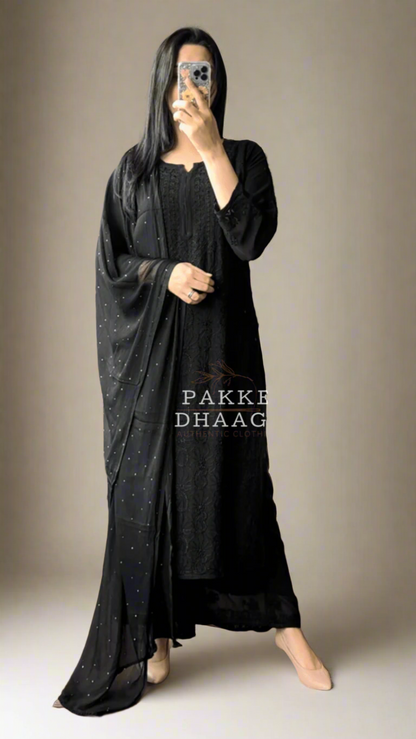 Person wearing a black chikankari handmade suit, flaunting a dupatta with mukaish work and intricate detail
