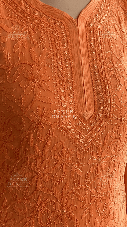 Close-up of an orange chikankari embroidered viscose garment