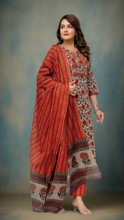 Woman wearing a red and beige patterned saree against a white background