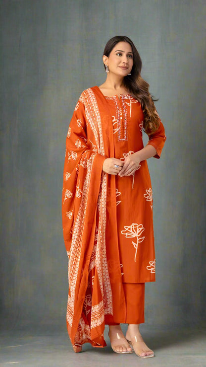 Woman wearing an orange traditional outfit with white patterns against a plain background