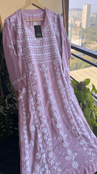 Mauve Chikankari Kurta with white floral patterns hanging against a cityscape view.